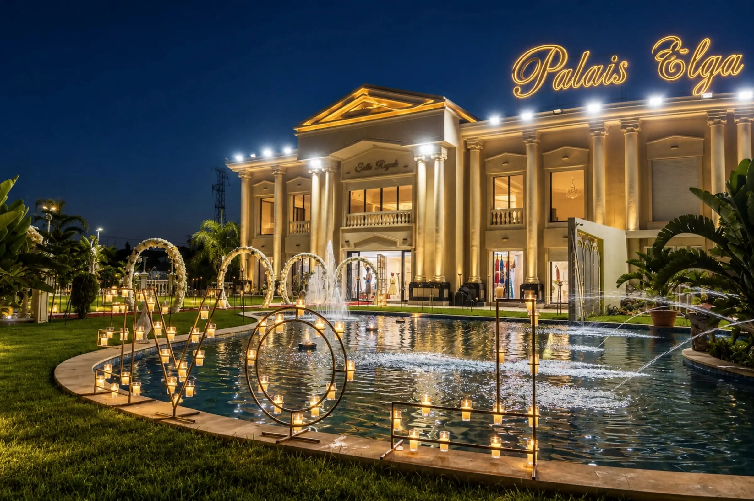 The lit façade reflected in the pool, floral arches and candles