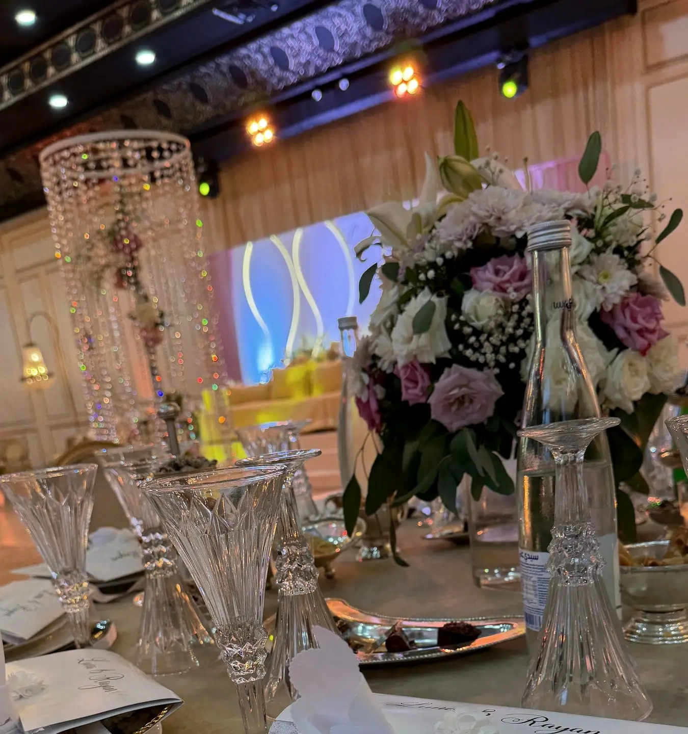 Floral centrepiece, crystal glasses and laid plates