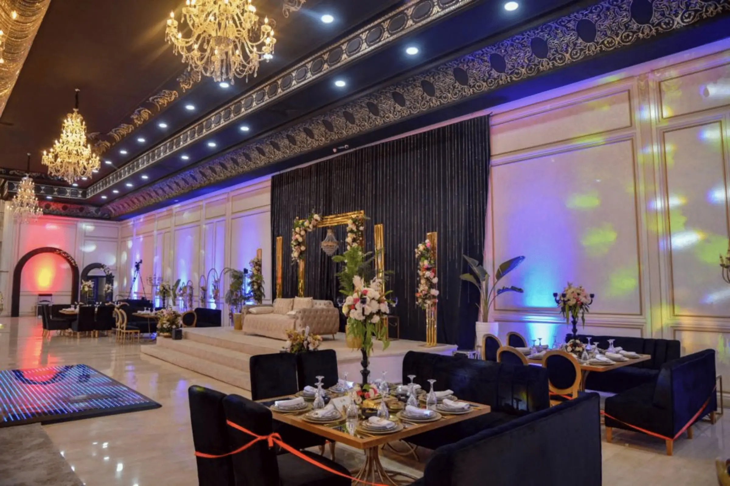 Salle Élégance aux drapés bleus, salons et tables basses sous les lustres