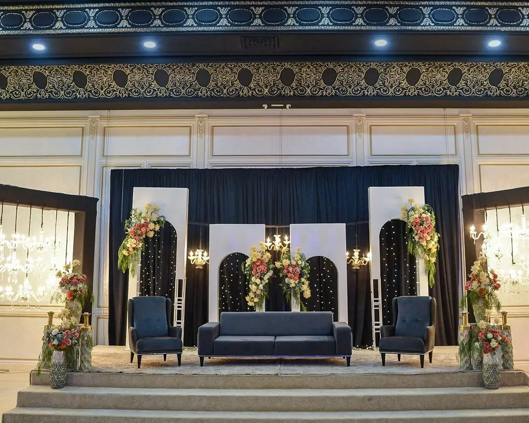 Black-and-gold kosha: settee and armchairs under a floral arch, gilt frieze