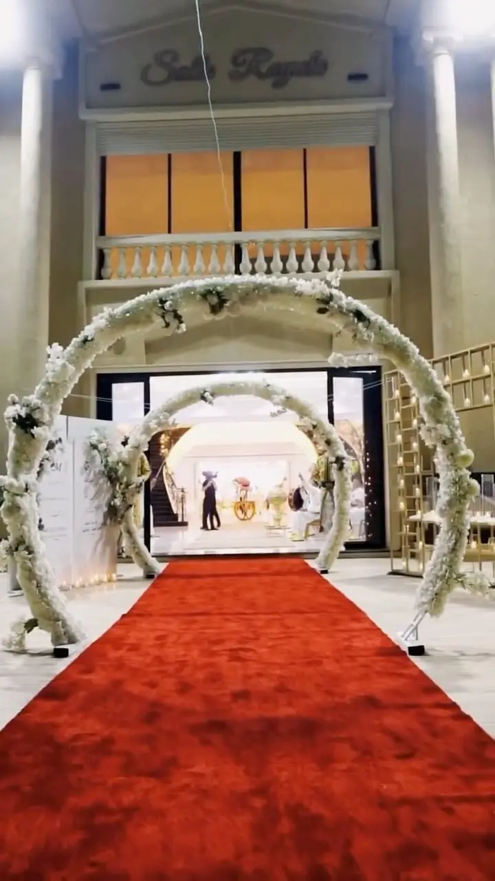Red carpet under white floral arches up to the Salle Royale entrance